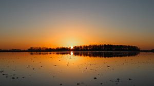 Zonsopkomst bij een ondergelopen stuk land van Karin Bijpost