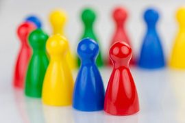 Conceptuele gekleurde speelpionnen in een rij