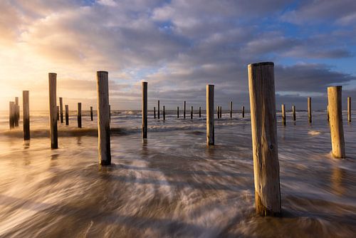 Zonsondergang op het strand bij Petten. Mooie wolkenluchten trekken voorbij met de koude noorden win