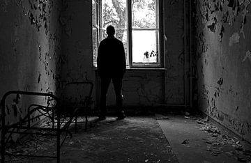 Depressiver Mensch steht an einem Fenster