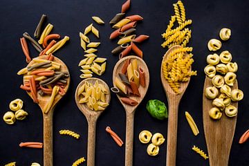 Pollepels met pasta, wooden spoons with Italian pasta.
