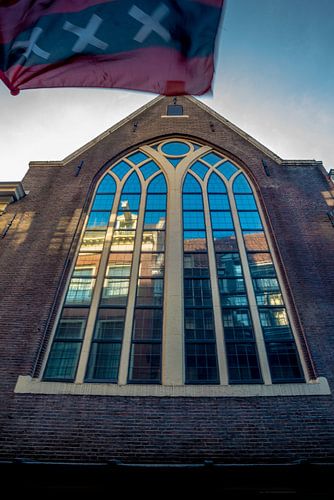 Gebouw met reflectie en de vlag van Amsterdam