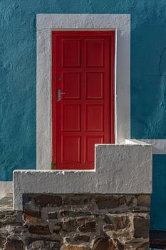 Wit omlijste rode deur in blauwe wand | Urbanfoto Afrika