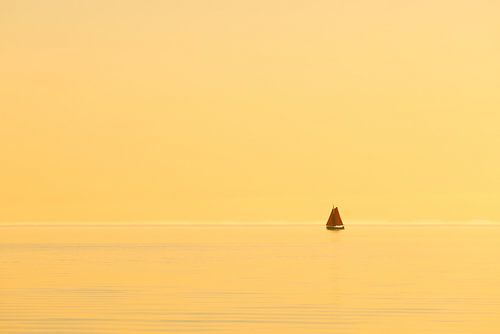 Een zeilschip op het IJsselmeer tijdens zonsondergang