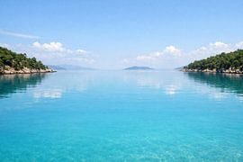 Une baie aux eaux bleues cristallines, dont la surface est lisse comme un miroir