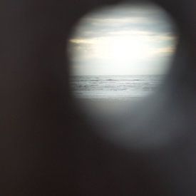 Doorkijkje naar de zee met zonsondergang van Evy Bakker