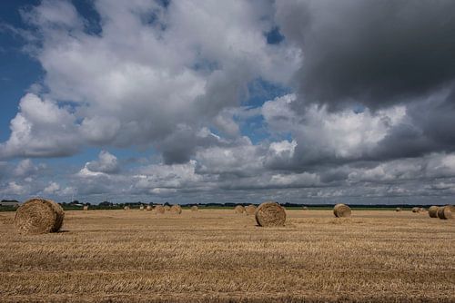 Strorollen op een akker met mooie wolkenluchten