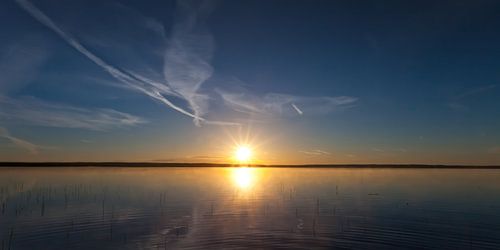 Dawn on the lake, dark blue water and pink dawn