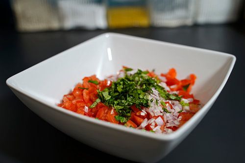 Tomaten, ui, basilicum in een kom.