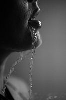 Woman with water flowing from her mouth, black and white