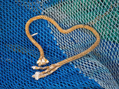 Fischernetz und ein Stück Seil, das in Form eines Herzens ausgelegt wird