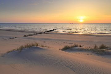 Zonsondergang strand met vissersboot aan de horizon van FotoBob