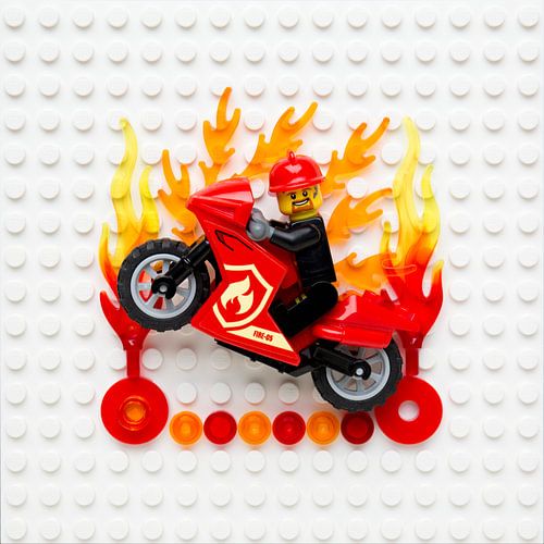 Lego Feuerwehrmann auf Motorrad springt durch Feuer