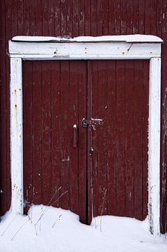 Dubbele roodbruine deur in de sneeuw