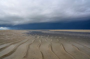 Naderende stormwolken boven het strand van Texel