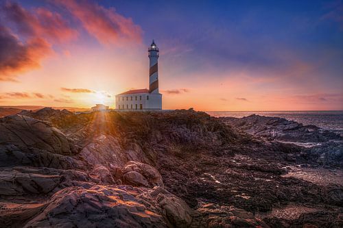 Eiland Menorca met vuurtoren aan prachtige kust bij zonsondergang.