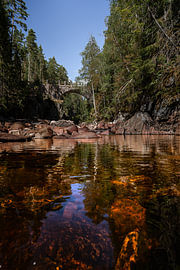 Schwedische Natur – Vertikaler Fotodruck der alten Steinbogenbrücke in der Brattfallet-Schlucht von Dylan Winter Visuals