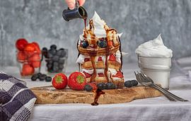 Köstlicher Pfannkuchennachtisch mit Erdbeeren, Blaubeeren und Schlagsahne. von D Meijer