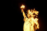  Freiheitsstatue mit brennendem Feuer isoliert auf schwarzem Hintergrund