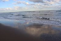 Wolken weerspiegelen in het laagwater van de zee