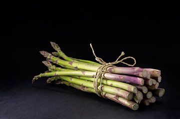 bunch of fresh green asparagus on a dark background changing to black, copy space by Maren Winter