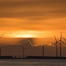 Sun sets over the Eastern Scheldt barrier with brilliant golden border along the clouds by Gert van Santen