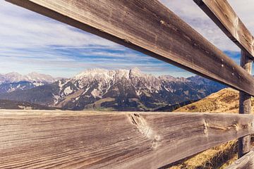 Blick auf die Alpen durch einen Holzzaun