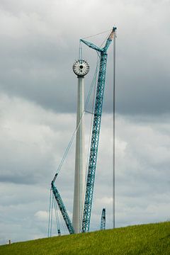 Bouw van een moderne windmolen aan de dijk in Nederland van Tonko Oosterink