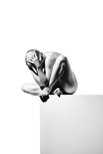 Hele mooie naakte vrouw poserend op een grijs blok