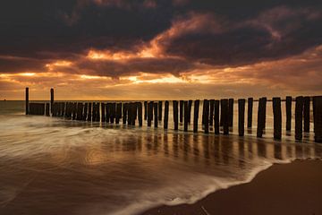 Dutch clouds and typical breakwater of wooden poles along the coast of Zeeland by gaps photography