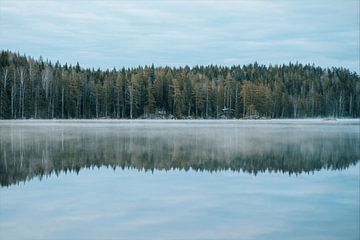 Hütten am Rande eines nebligen Sees in Schweden von Joep van de Zandt