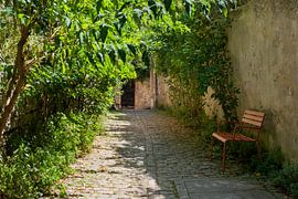 A quaint little French alleyway with a bench