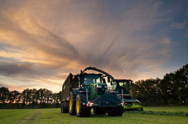 Tractor en grashakselaar doen de grasoogst