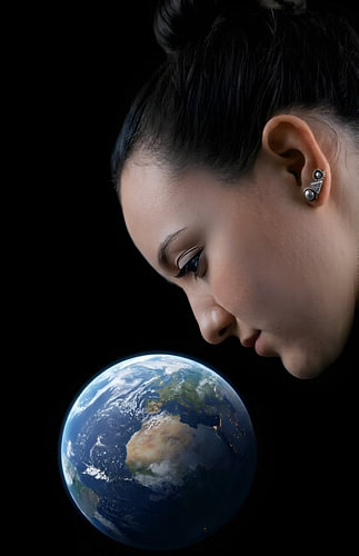 A woman looks at the Earth in the dark