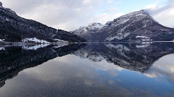 Spiegelung der schneebedeckten Berge im Vangsee in Norwegen von Aagje de Jong