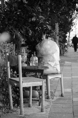 Siège créatif (désordonné) avec lampes à huile sur le trottoir (photo en noir et blanc)