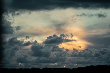 dramatische lucht met wolkenpartij en zon achter de wolken van Eric van Nieuwland