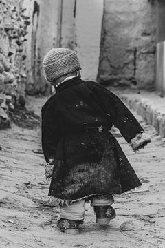 Kleine jongen wandelt door een straat