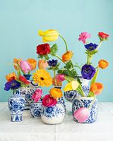 Uitbundig stilleven met tulp, ranonkel, anemoon, gerbera in  delfts blauwe vaasjes blauwe achtergron