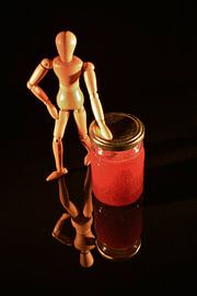 Obstkonserven mit Holzpuppe und schwarzem Hintergrund von Hans-Jürgen Janda