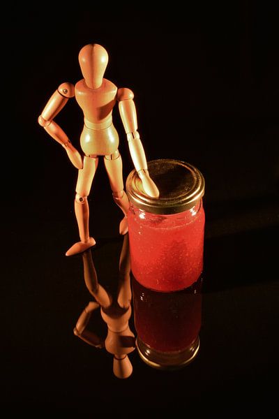 Canned fruit with wooden doll and black background by Hans-Jürgen Janda