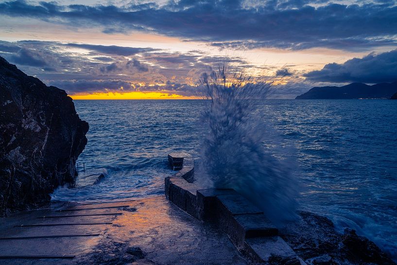 Grande éclaboussure d'eau après une grosse vague frappant la côte au coucher du soleil par Robert Ruidl