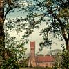 Church Midwolde in a frame with tree branches in portrait position by R Smallenbroek
