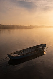 A misty sunrise by a small rowing boat