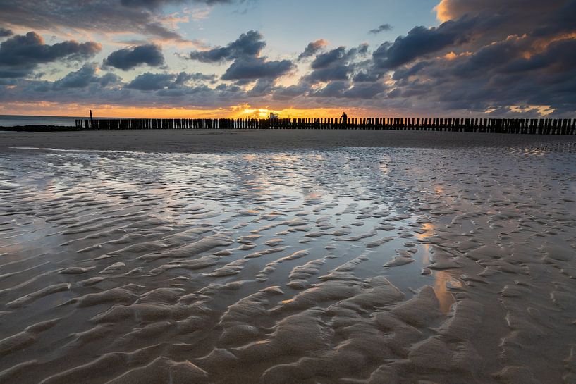spectacular sunset on the Zeeland beach with the typical Dutch breakwaters by Kim Willems