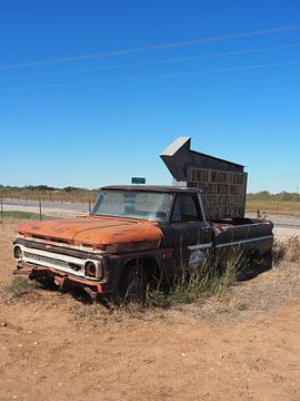 Roestige pickup truck als wegwijzer naar muzikale stad in Texas
