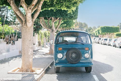Blauwe retro volkswagen hippie bus in een straat van Ibiza