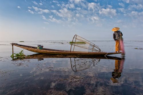 FISHERMAN AT SUNRISE vist ON TRADITIONAL WAY TO INLE LAKE IN MYANMAR. With a basket the fish is caug