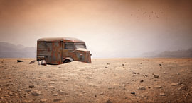 Un bus abandonné dans un paysage de sable sur DAX Photography
