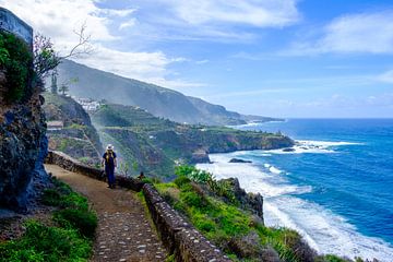 Walker walks along a path overlooking the sea and cliffs. by Lidewij Olive